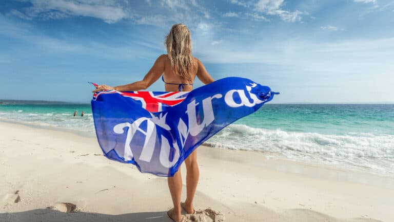 Mujer con bandera australiana en una playa de Australia