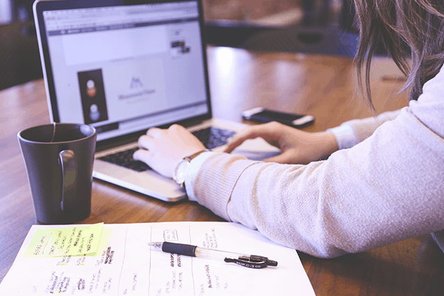 Mujer escribiendo en una computadora