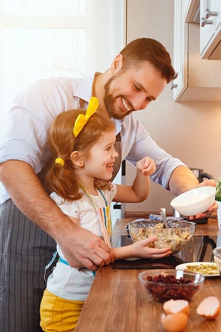 hombre enseñando a cocinar a una niña