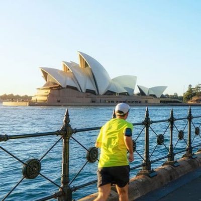 hombre corriendo frente al Opera House de Sydney